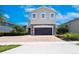 Charming two-story home with a two-car garage, stone accents, and a neatly paved driveway at 311 W Falls Dr, Kissimmee, FL 34747