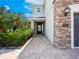 Inviting front entrance with a brick pathway leading to a front door with glass and stone accents at 311 W Falls Dr, Kissimmee, FL 34747