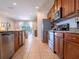 Modern kitchen with stainless steel appliances, granite counters, and wood cabinetry at 311 W Falls Dr, Kissimmee, FL 34747