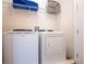 Laundry area with white washer and dryer, wire shelving with laundry supplies at 311 W Falls Dr, Kissimmee, FL 34747