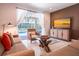 Relaxing living room boasts a pool view through sliding glass doors, comfy seating, and a sleek entertainment center at 311 W Falls Dr, Kissimmee, FL 34747