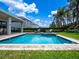 Sparkling pool and spa with sunny backyard featuring lush landscaping and lounge chairs, perfect for relaxation at 311 W Falls Dr, Kissimmee, FL 34747