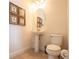 Elegant half-bath featuring pedestal sink, oval mirror, neutral color palette, and nautical-themed decor at 311 W Falls Dr, Kissimmee, FL 34747