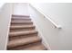 Carpeted staircase with white railing and natural lighting at 311 W Falls Dr, Kissimmee, FL 34747