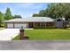 Charming single-story brick home with a well-manicured lawn, a three-car garage and mature trees at 3285 Majestic Oak Dr, St Cloud, FL 34771