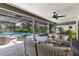 View of covered lanai with ceiling fan, outdoor seating, and screened-in pool at 3285 Majestic Oak Dr, St Cloud, FL 34771