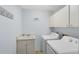 Dedicated laundry room with a sink, cabinets, and modern washer and dryer units at 3285 Majestic Oak Dr, St Cloud, FL 34771