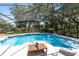View of sparkling screened-in pool with potted plant on table at 3285 Majestic Oak Dr, St Cloud, FL 34771