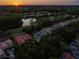 Aerial view of a home with a pool, surrounded by mature trees, at sunset at 3352 Park Grove Ct, Longwood, FL 32779