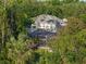 Aerial view of home with screened in pool surrounded by mature tropical landscaping at 3352 Park Grove Ct, Longwood, FL 32779