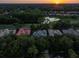 Aerial view of residential homes with ponds and mature trees at sunset at 3352 Park Grove Ct, Longwood, FL 32779
