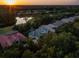 Aerial view of a neighborhood with mature trees, ponds, and single Gathering homes at sunset at 3352 Park Grove Ct, Longwood, FL 32779