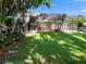 Large backyard featuring lush green lawn and mature trees, with a screened in porch at 3352 Park Grove Ct, Longwood, FL 32779