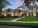 Charming two-story home with a landscaped front yard, illuminated walkway and welcoming double-door entrance at 3352 Park Grove Ct, Longwood, FL 32779