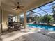 Screened lanai with a fan offers an inviting spot to unwind with views of the pool and landscaped yard at 3352 Park Grove Ct, Longwood, FL 32779