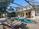 Beautiful screened-in pool and spa with lounge chairs, patio table and a well-manicured patio area at 3352 Park Grove Ct, Longwood, FL 32779
