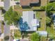 A bird's-eye view shows a home with a gray roof, green lawn, and mature trees in the backyard at 3714 Paige St, Port Orange, FL 32127