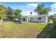 View of the home's backyard featuring a lawn, covered outdoor area, and mature trees at 3714 Paige St, Port Orange, FL 32127