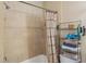 Shower featuring neutral tiles, a shower curtain and a shelving unit for toiletries at 3721 S Lake Orlando Pkwy # 05, Orlando, FL 32808