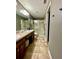Bathroom with a double sink vanity, neutral tile floor and a glass-enclosed shower at 4297 Abaco Dr, Tavares, FL 32778