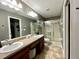 Bathroom featuring a double sink vanity, large mirror, and glass-enclosed shower at 4297 Abaco Dr, Tavares, FL 32778