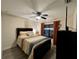 Cozy bedroom featuring hardwood floors, a ceiling fan, and a window with orange curtains at 4297 Abaco Dr, Tavares, FL 32778