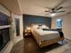Modern main bedroom featuring a wood frame bed, moody accent wall, and ensuite bathroom at 4297 Abaco Dr, Tavares, FL 32778