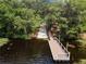 Aerial view of a boat launch and dock surrounded by mature trees leading to a lake at 455 Lazio Cir, Debary, FL 32713