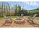 Relaxing backyard featuring a fire pit with chairs surrounded by lush bamboo and a pea gravel area at 455 Lazio Cir, Debary, FL 32713