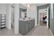 Bright bathroom featuring double sinks, gray cabinets, and a view into the water closet and bedroom at 455 Lazio Cir, Debary, FL 32713