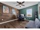 Bedroom with wood accent wall, featuring a ceiling fan and comfortable seating area at 455 Lazio Cir, Debary, FL 32713