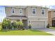 Charming two-story home featuring a manicured lawn and a two-car garage at 455 Lazio Cir, Debary, FL 32713