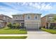 Charming two-story home with a manicured lawn and a brick-paved driveway leading to a two-car garage at 455 Lazio Cir, Debary, FL 32713