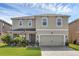 Two-story house featuring a front lawn, two-car garage, and well-manicured landscaping at 455 Lazio Cir, Debary, FL 32713