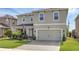 Charming two-story home with a manicured lawn and a brick-paved driveway leading to a two-car garage at 455 Lazio Cir, Debary, FL 32713