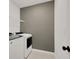 Laundry room with modern appliances, including a washer and dryer, and a wire shelf for storage at 455 Lazio Cir, Debary, FL 32713