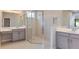 Bathroom featuring a glass-enclosed shower and dual vanities with modern fixtures at 4704 Coral Harbour Rd, Kissimmee, FL 34758