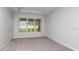 Bedroom showcasing a large window with blinds, neutral carpet, and ample natural light at 4704 Coral Harbour Rd, Kissimmee, FL 34758