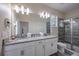 Well lit bathroom featuring double sinks with granite countertops and a glass-enclosed shower at 4807 Kings Castle Cir, Kissimmee, FL 34746