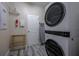 Laundry room equipped with new stackable washer and dryer with gray floors at 4807 Kings Castle Cir, Kissimmee, FL 34746