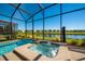 Screened-in pool and spa area overlooking a tranquil pond at 4807 Kings Castle Cir, Kissimmee, FL 34746
