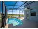 Backyard pool featuring a screened enclosure offering stunning views of the lake at 4807 Kings Castle Cir, Kissimmee, FL 34746