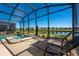 Inviting screened-in pool area with lounge chairs and a view of the serene pond at 4807 Kings Castle Cir, Kissimmee, FL 34746