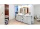 Well-lit bathroom featuring a double vanity, neutral tile flooring, and classic design at 511 E Mirror Lake Dr, Fruitland Park, FL 34731