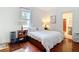 Bright bedroom featuring hardwood floors, a plush bed, and stylish bedside tables with lamps at 511 E Mirror Lake Dr, Fruitland Park, FL 34731