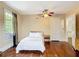Bedroom features hardwood floors, natural light, and a view into the hallway at 511 E Mirror Lake Dr, Fruitland Park, FL 34731