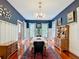 Elegant dining room with a chandelier, large windows, and classic wainscoting at 511 E Mirror Lake Dr, Fruitland Park, FL 34731