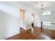 Hallway features hardwood floors, white walls, and classic trim with a view into bedroom at 511 E Mirror Lake Dr, Fruitland Park, FL 34731