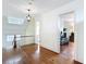 Hallway features hardwood floors, detailed banister, and view into a room with neutral colors at 511 E Mirror Lake Dr, Fruitland Park, FL 34731
