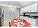 Kitchen with white cabinets, modern appliances, black countertops, and a red retro dining table at 511 E Mirror Lake Dr, Fruitland Park, FL 34731